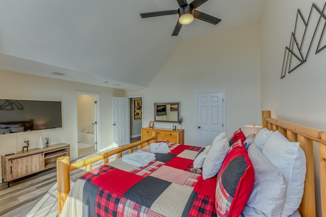 bedroom featuring hardwood / wood-style flooring, ceiling fan, lofted ceiling, and connected bathroom