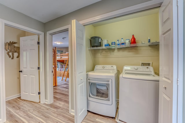 laundry area featuring independent washer and dryer and light hardwood / wood-style flooring