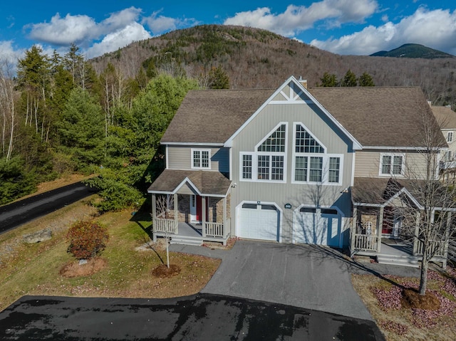 view of front of house featuring a mountain view, covered porch, and a garage