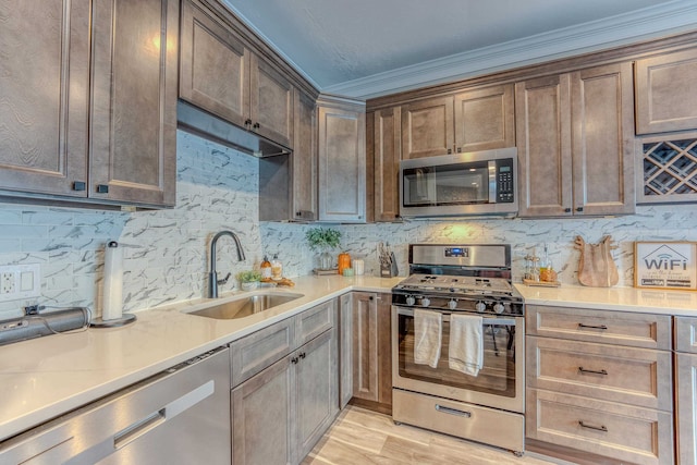 kitchen with backsplash, sink, ornamental molding, and stainless steel appliances