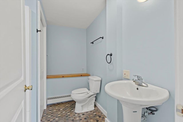 bathroom featuring toilet, sink, and a baseboard heating unit