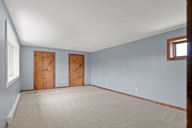 unfurnished bedroom featuring carpet floors and a baseboard radiator