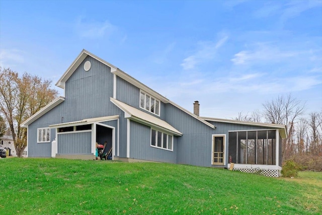 rear view of house with a yard and a sunroom