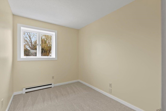 spare room with light colored carpet, a textured ceiling, and a baseboard radiator