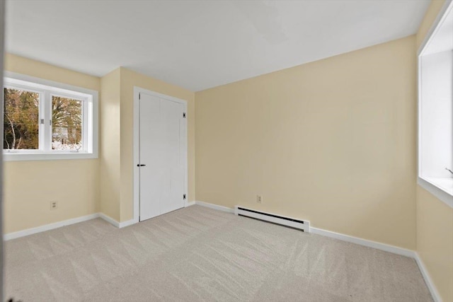 carpeted spare room featuring baseboard heating