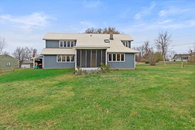 rear view of property featuring a sunroom and a yard