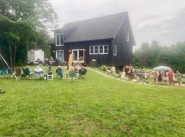 back of house with an outbuilding and a yard