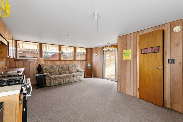 carpeted living room featuring wood walls, a wealth of natural light, and sink