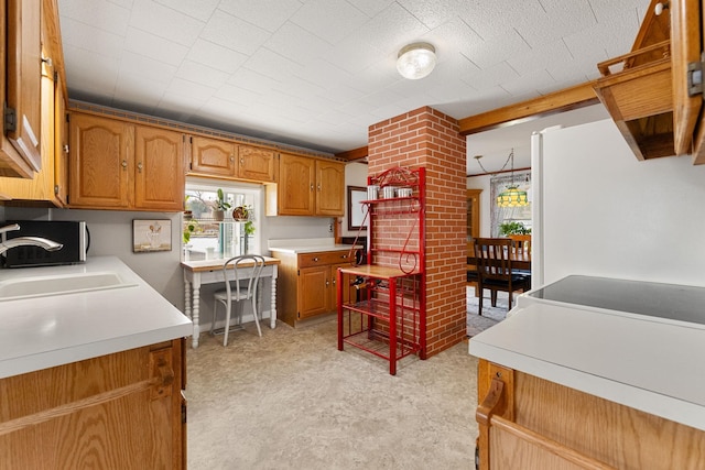 kitchen featuring ornate columns, light colored carpet, and sink