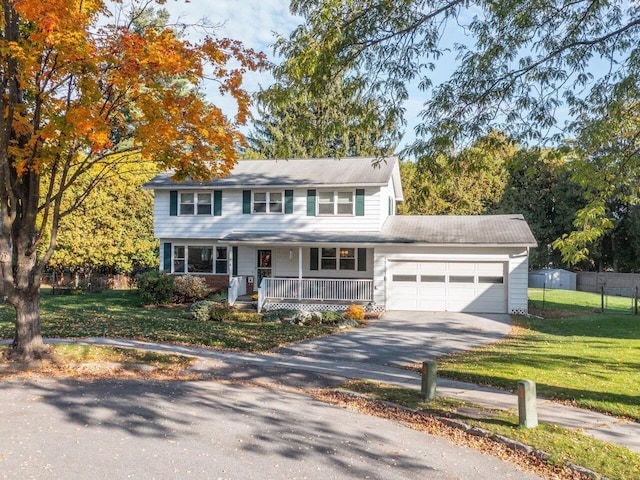 view of front of home with a front yard, covered porch, and a garage