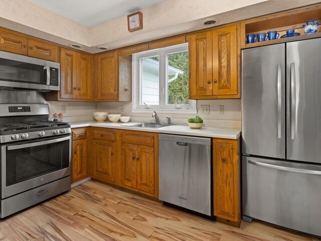 67 Case Pkwy, Burlington, VT 05401 - kitchen with appliances with stainless steel finishes, a sink, brown cabinetry, and light countertops