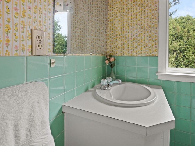 67 Case Pkwy, Burlington, VT 05401 - bathroom featuring tile walls, vanity, healthy amount of natural light, wallpapered walls, and a wainscoted wall