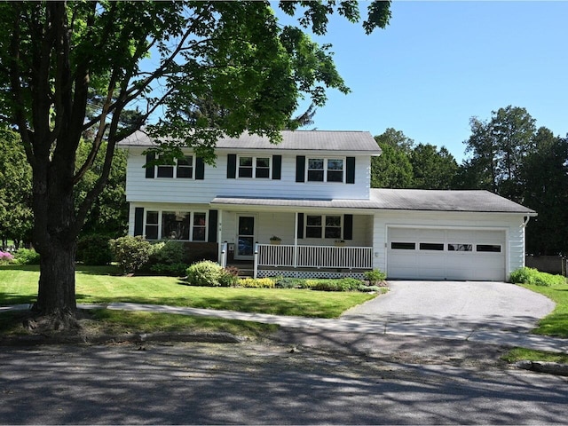 67 Case Pkwy, Burlington, VT 05401 - view of front of house with a porch, driveway, an attached garage, a front lawn, and metal roof