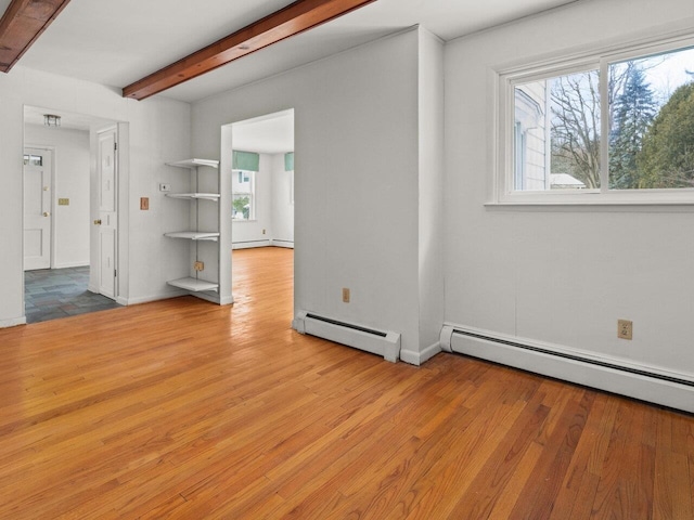 67 Case Pkwy, Burlington, VT 05401 - empty room with a baseboard radiator, healthy amount of natural light, beamed ceiling, wood finished floors, and baseboards