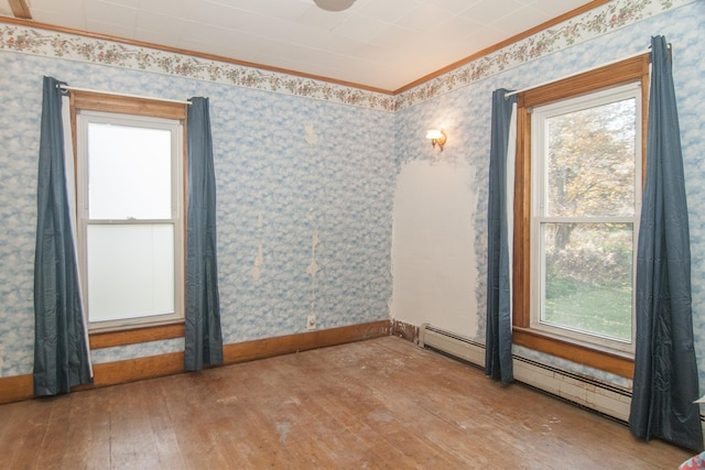 43 Maple St, Orleans, VT 06860 - spare room with healthy amount of natural light, wood-type flooring, crown molding, wallpapered walls, and a baseboard heating unit
