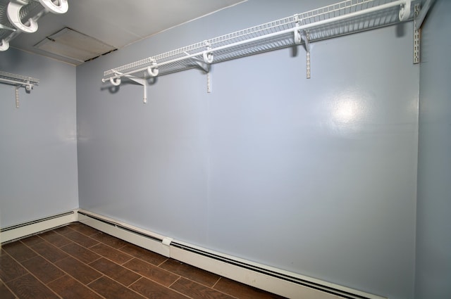 walk in closet featuring a baseboard radiator and dark hardwood / wood-style flooring