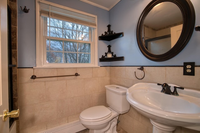 bathroom featuring sink, tile walls, baseboard heating, toilet, and crown molding