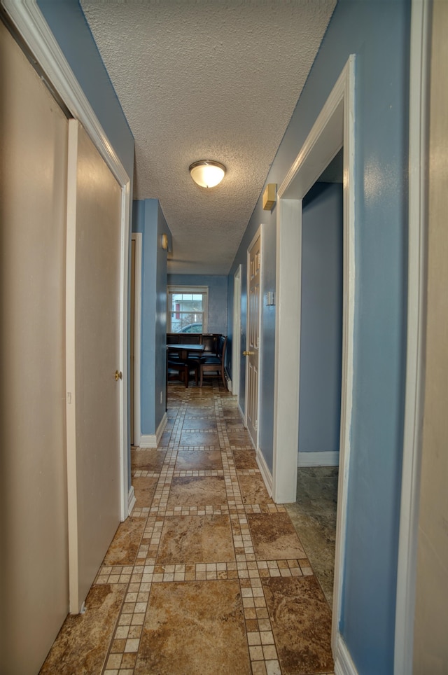 hall with a textured ceiling