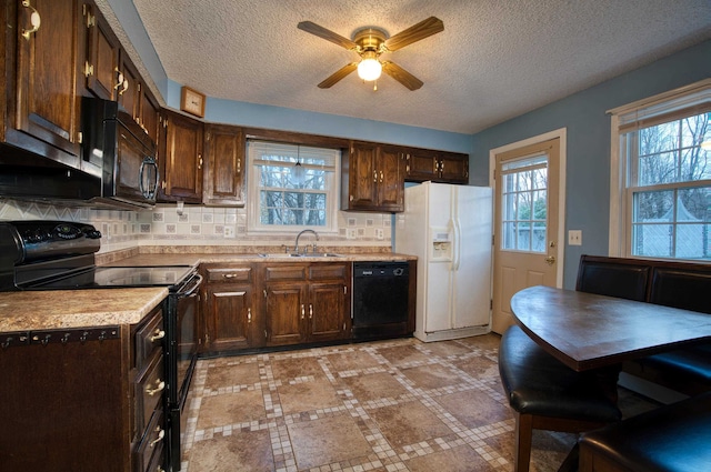 kitchen featuring dark brown cabinetry, sink, black appliances, ceiling fan, and backsplash