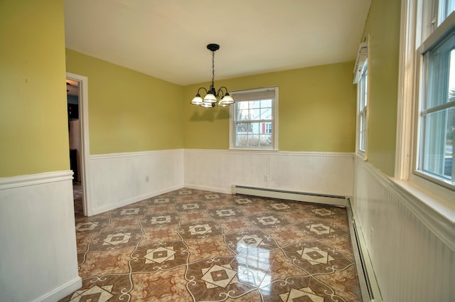 unfurnished dining area with baseboard heating and an inviting chandelier