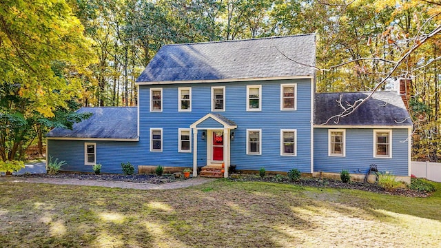 colonial-style house featuring a front yard