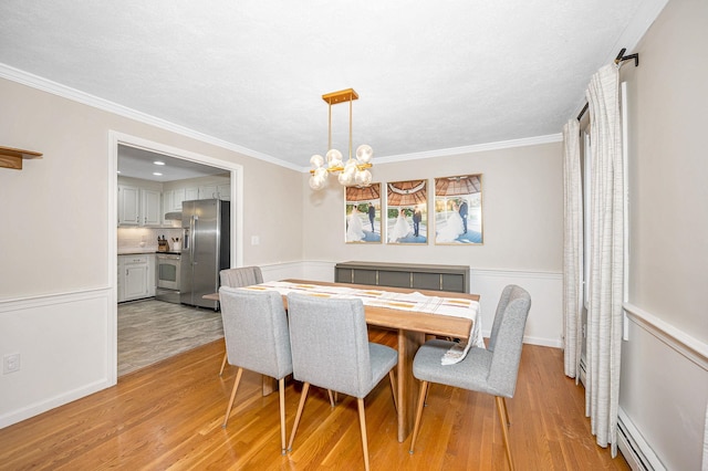 dining space with light hardwood / wood-style floors, a chandelier, a baseboard radiator, and crown molding