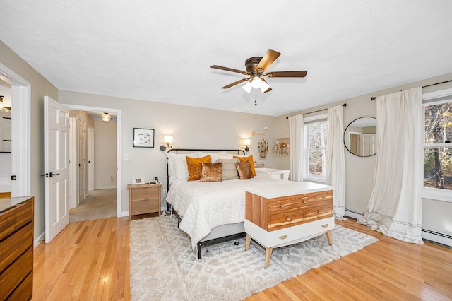 bedroom with light wood-type flooring, multiple windows, and ceiling fan