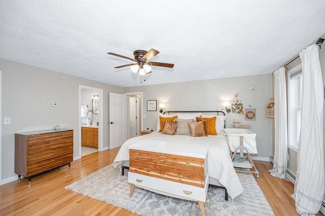 bedroom featuring ensuite bathroom, a textured ceiling, ceiling fan, and light hardwood / wood-style flooring