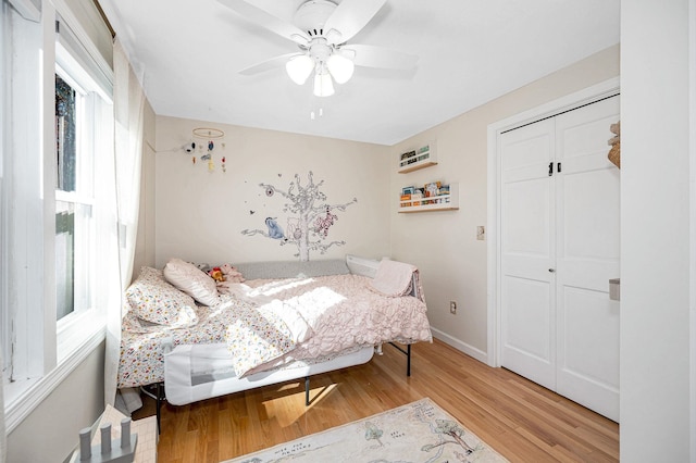 bedroom with hardwood / wood-style flooring, ceiling fan, and a closet