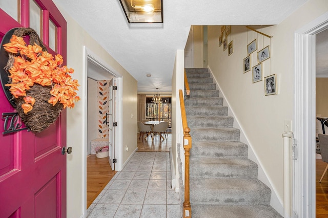 foyer with light wood-type flooring and a textured ceiling