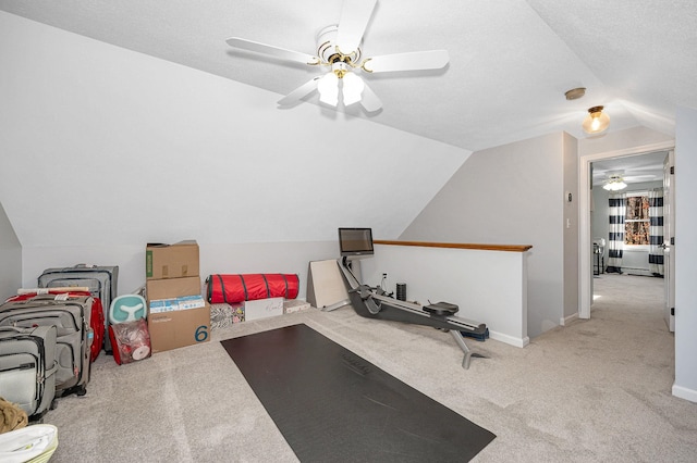 exercise area featuring a textured ceiling, light colored carpet, lofted ceiling, and ceiling fan