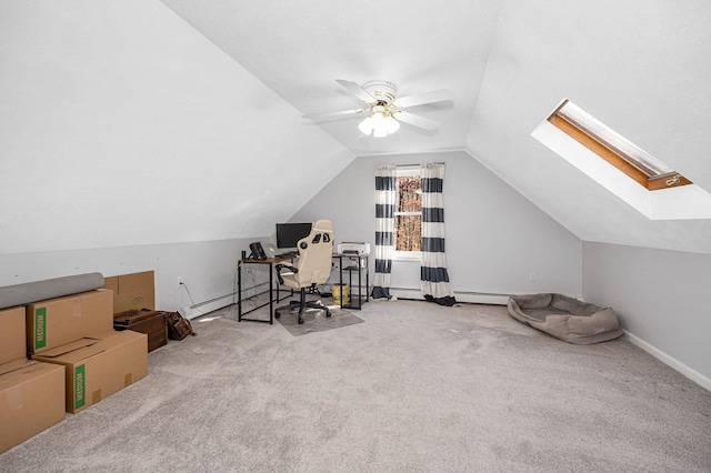 carpeted office featuring vaulted ceiling with skylight and ceiling fan