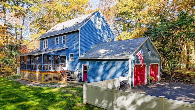 exterior space featuring a garage, a sunroom, and a yard