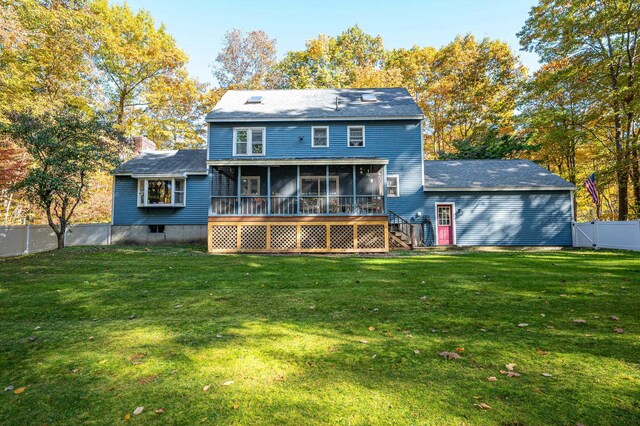 back of property with a lawn and a sunroom