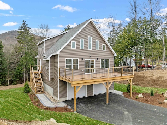 back of property with a garage and a deck with mountain view