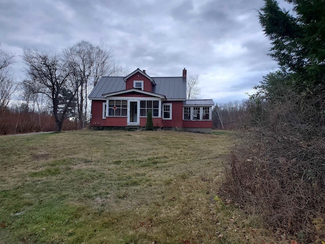 view of front of house with a front yard and a sunroom