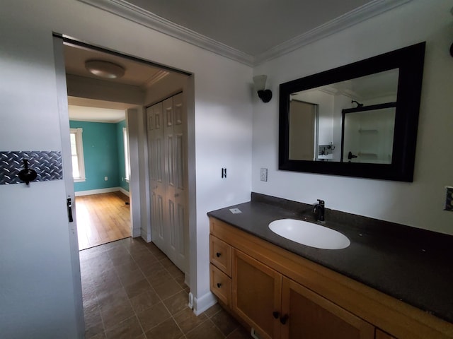 bathroom featuring hardwood / wood-style floors, vanity, and crown molding