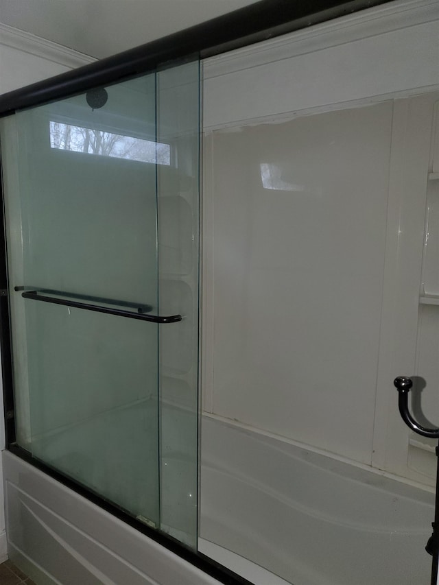 bathroom with bath / shower combo with glass door