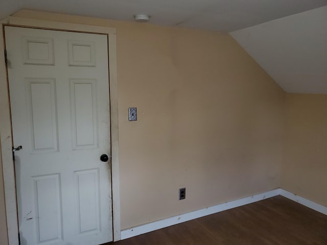 bonus room with dark hardwood / wood-style floors and vaulted ceiling