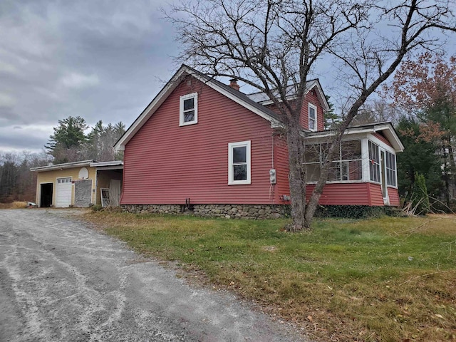 view of home's exterior featuring a sunroom and a yard