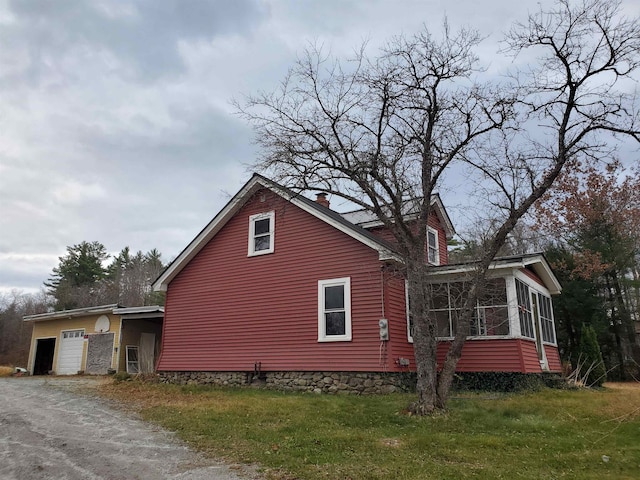 view of side of home featuring a sunroom and a yard