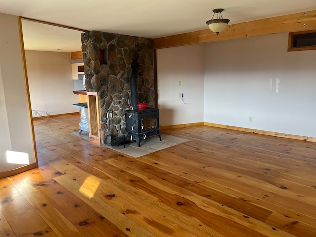 unfurnished living room with a wood stove and light hardwood / wood-style floors