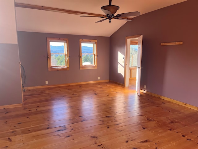 spare room featuring light hardwood / wood-style flooring, ceiling fan, and vaulted ceiling