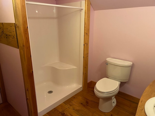 bathroom with walk in shower, toilet, and hardwood / wood-style floors