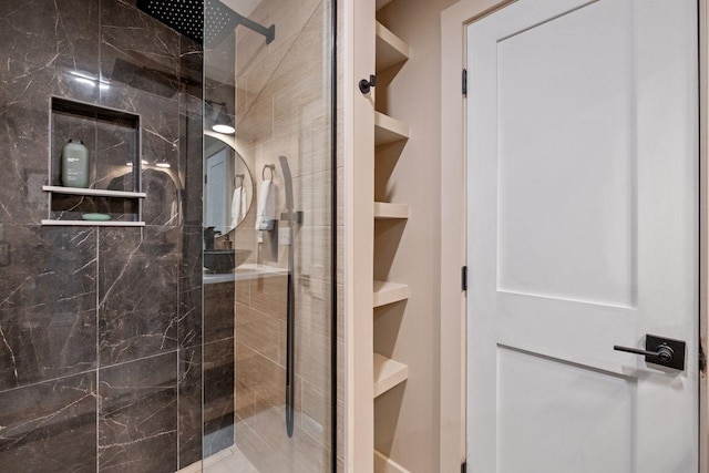 bathroom featuring built in shelves and a shower with shower door