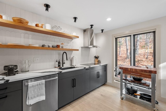 kitchen with decorative backsplash, sink, dishwasher, wall chimney exhaust hood, and light hardwood / wood-style flooring