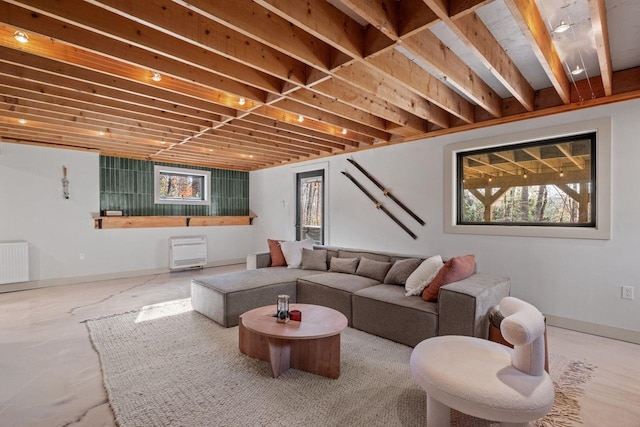 living room with radiator, concrete flooring, and a healthy amount of sunlight