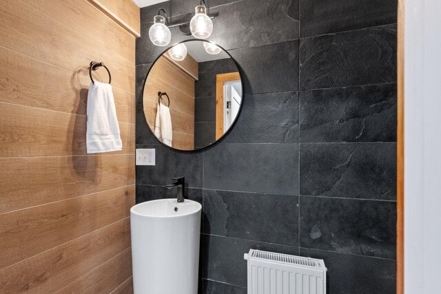 bathroom featuring tile walls and radiator heating unit