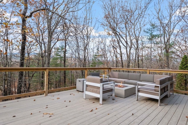 wooden deck featuring an outdoor living space with a fire pit