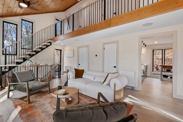 living room featuring high vaulted ceiling, radiator, wooden ceiling, and light hardwood / wood-style floors